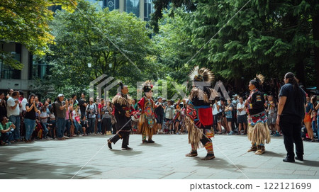 Indigenous dancers perform traditional dance in a city park, surrounded by spectators. Indigenous dancers perform traditional dance in a city park, surrounded by spectators. 122121699