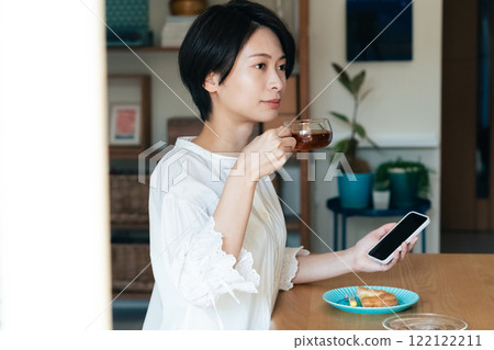 A woman watching a smartphone while eating A woman watching a smartphone while eating 122122211