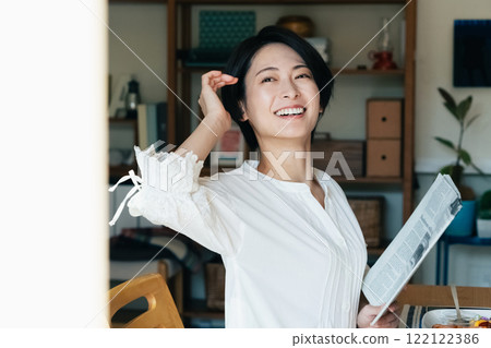 Smiling woman looking outside from indoors Smiling woman looking outside from indoors 122122386