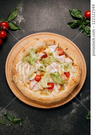 Fresh salad pizza with turkey, lettuce, cherry tomatoes, and egg slices on a wooden board Fresh salad pizza with turkey, lettuce, cherry tomatoes, and egg slices on a wooden board 122122549