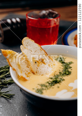 Creamy cheese soup with toasted bread slices garnished with fresh dill, perfect for a business lunch 122122590