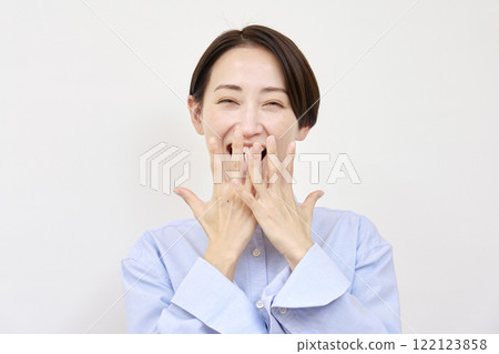 驚訝的女人微笑著，白色背景，看著相機 122123858