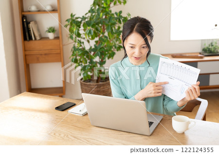Middle-aged woman having an online meeting on a computer 122124355
