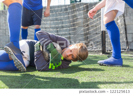 Goalkeeper catches ball in the penalty area. Young teen soccer game 122125613