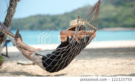Lifestyle freelance man relax and sleeping on the hammock after using laptop working and relax on the beach Lifestyle freelance man relax and sleeping on the hammock after using laptop working and relax on the beach 122125750