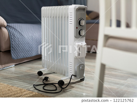 Heating surface of oil heater is on foreground and home space is on background 122125762