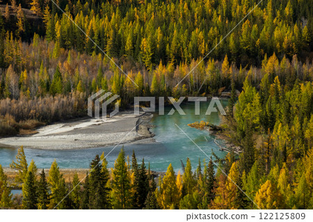 Beautiful lake surrounded by golden autumn forest and lush green trees 122125809