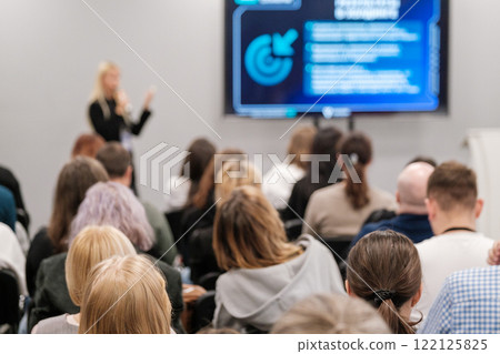 Audience attending a business presentation in a modern conference room Audience attending a business presentation in a modern conference room 122125825