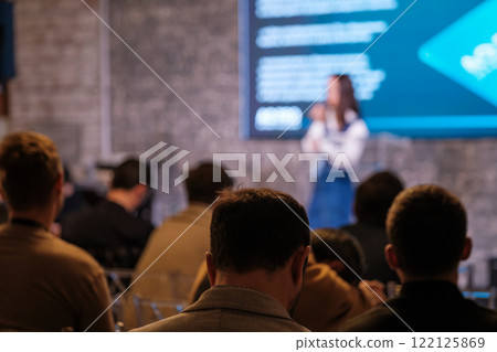 Audience attending a conference with speaker on stage Audience attending a conference with speaker on stage 122125869