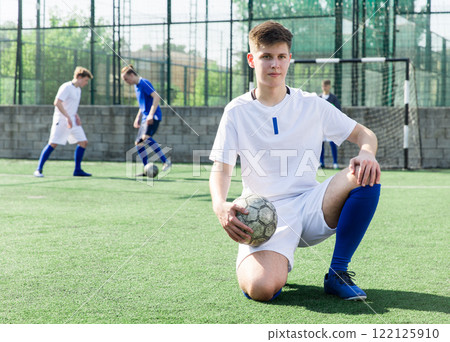 Youth football player sitting on field 122125910