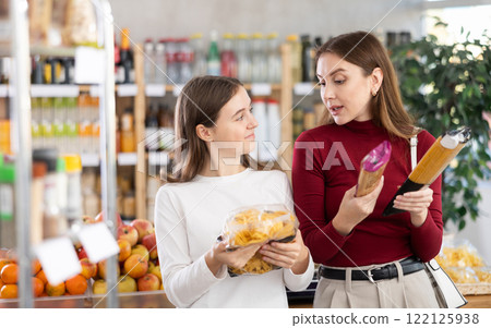 Mother and daughter choose pasta and spaghetti Mother and daughter choose pasta and spaghetti 122125938