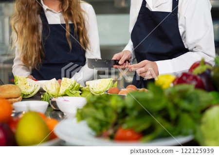 Close up hand Chef the group children cut vegetables in class kitchen room. Close up hand Chef the group children cut vegetables in class kitchen room. 122125939