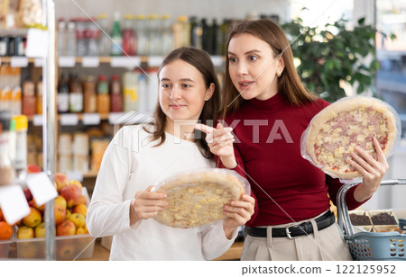 Teenage girl and her mother choosing pizza in grocery store Teenage girl and her mother choosing pizza in grocery store 122125952