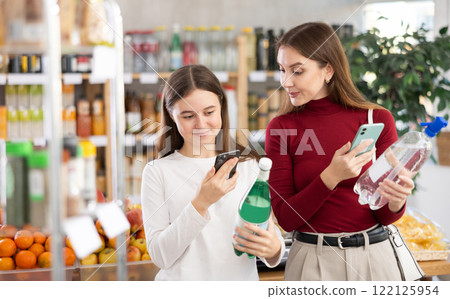 Mom and daughter scanning soda bottles Mom and daughter scanning soda bottles 122125954