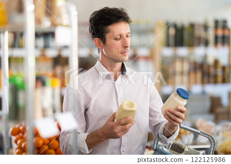 man chooses mayonnaise in the store 122125986