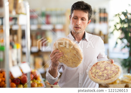 Man choosing pizza in the store Man choosing pizza in the store 122126013