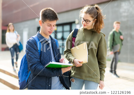 Teenage girl and boy talking outside 122126196