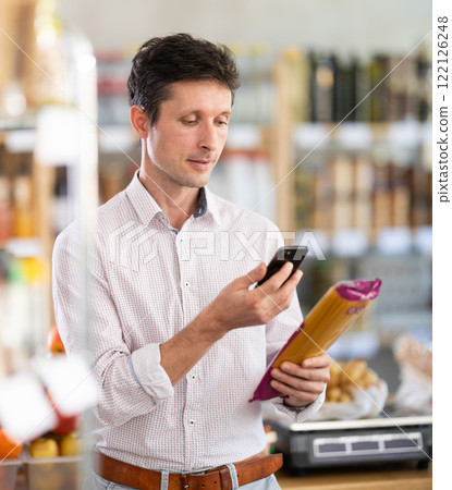 Man scanning pasta in store 122126248
