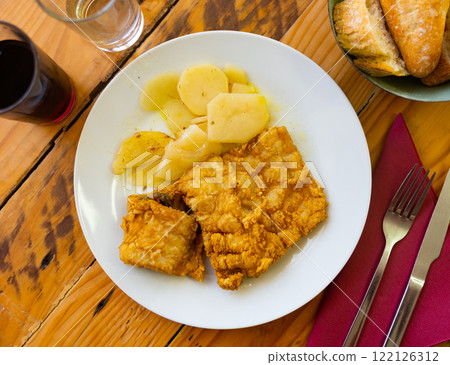 Fried cod fillet in crispy breading with potatoes Fried cod fillet in crispy breading with potatoes 122126312