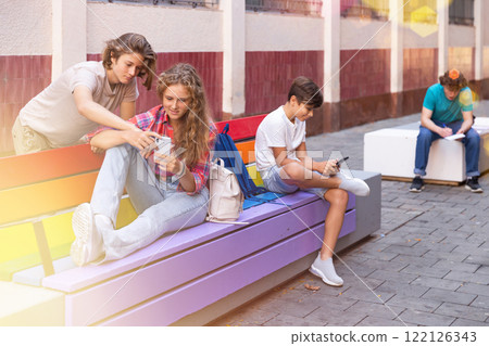 Group of teens hanging out outdoors Group of teens hanging out outdoors 122126343