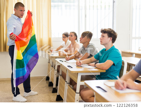 Teenage schoolboy listening to teacher talking about LGBT at lesson Teenage schoolboy listening to teacher talking about LGBT at lesson 122126358