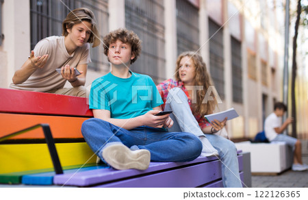 Guy points his hand at someone in company of friends Guy points his hand at someone in company of friends 122126365