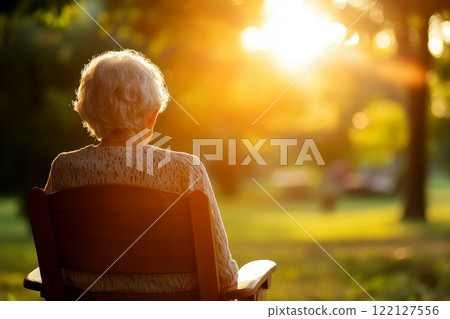back of view of lonely old woman sitting by her selves with sun light flare on background. 122127556