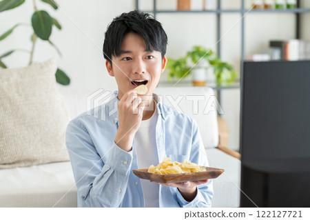 Young man watching tv in the living room Young man watching tv in the living room 122127721