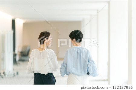 Back view of a woman walking in the office 122127956