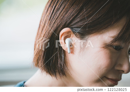Woman wearing wireless earphones 122128025