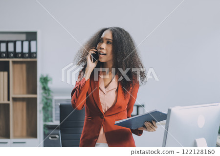 Black businesswoman talking on telephone at desk 122128160