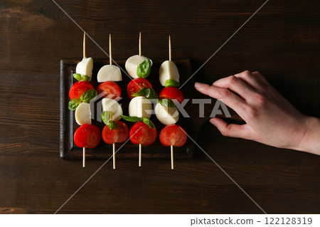 Caprese salad on skewers on a dark background Caprese salad on skewers on a dark background 122128319