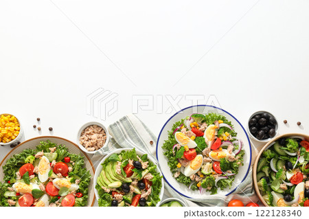 Cooking salad with tuna on a light background. Cooking salad with tuna on a light background. 122128340