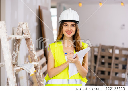 Young attractive woman in uniform makes notes on pape 122128523