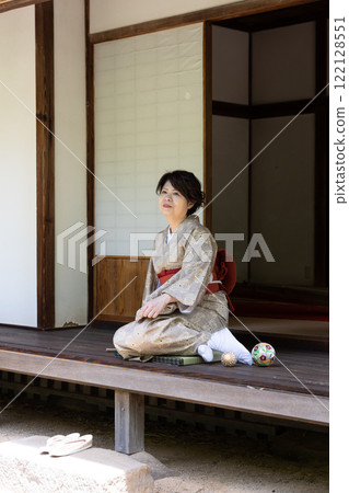 A woman sitting on the veranda with her legs slightly tilted A woman sitting on the veranda with her legs slightly tilted 122128551