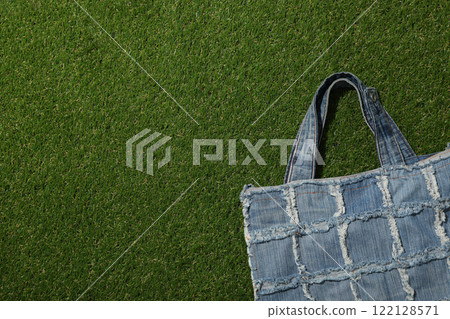 Handmade denim bag on green background, space for text Handmade denim bag on green background, space for text 122128571