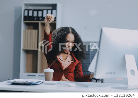 Excited african American woman sit at desk feel euphoric win online lottery, happy black woman overjoyed get mail at laptop being promoted at work, biracial girl amazed read good news at computer 122129264