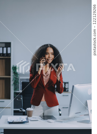 Black businesswoman talking on telephone at desk 122129266
