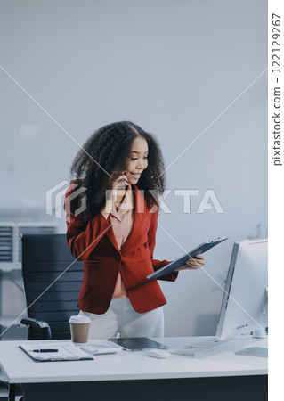 Black businesswoman talking on telephone at desk Black businesswoman talking on telephone at desk 122129267