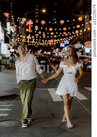Charming couple strolling under festive city lights, fully embracing their special moment 122129574