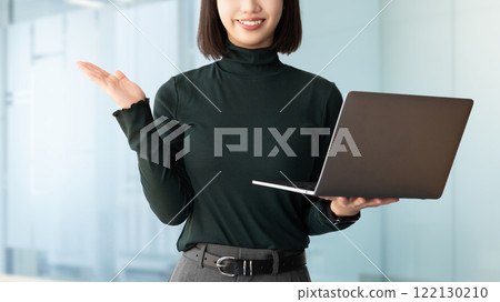 一位微笑的女商人拿著電腦並提供指導 122130210