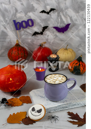 Halloween pumpkin and mug of coffee with cookies on the background of a gray wall with ghosts, bats, spiders, candles, pumpkins. leaves. Selective focus. Halloween pumpkin and mug of coffee with cookies on the background of a gray wall with ghosts, bats, spiders, candles, pumpkins. leaves. Selective focus. 122130439