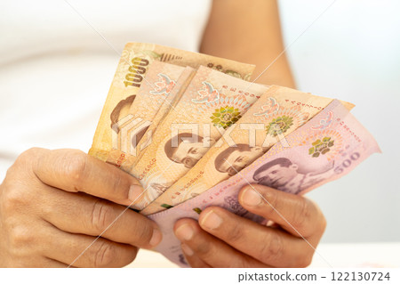 Asian woman holding Thai banknotes money, economy finance exchange trade investment. Asian woman holding Thai banknotes money, economy finance exchange trade investment. 122130724