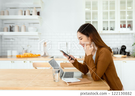 Happy young asian woman relax in domestic kitchen at home 122130882