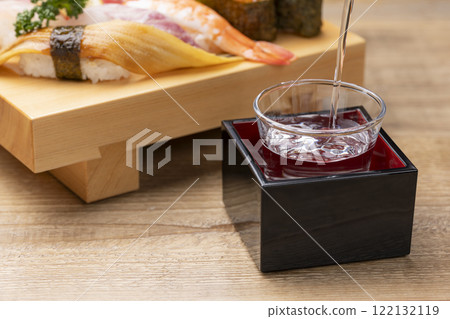 桌上擺滿了壽司和清酒 122132119
