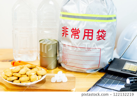 Dry bread, rock sugar, fish sausages, canned food, and drinking water lined up alongside disaster prevention supplies. 122132219