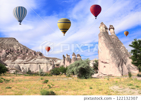 The balloon flight, famous tourist attraction of Cappadocia. Air balloons and Fairy Chimney (multihead stone mushrooms) in Pasabag Valley, Cappadocia, Anatolia, Turkey The balloon flight, famous tourist attraction of Cappadocia. Air balloons and Fairy Chimney (multihead stone mushrooms) in Pasabag Valley, Cappadocia, Anatolia, Turkey 122132307