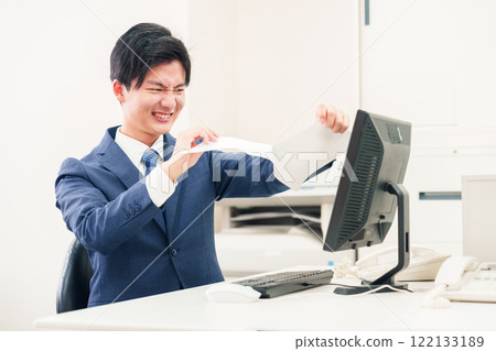 Businessman tearing up documents in the office Businessman tearing up documents in the office 122133189