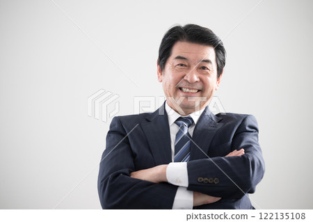 一名男子抱著雙臂看著鏡頭，因銷售或商務談判等方面的成功而大笑。 122135108