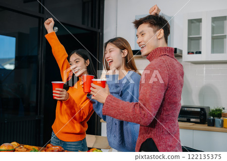 Drinks and conversation, social gathering and get together. Young people, eating pizza and happiness, celebration at home. Drinks and conversation, social gathering and get together. Young people, eating pizza and happiness, celebration at home. 122135375